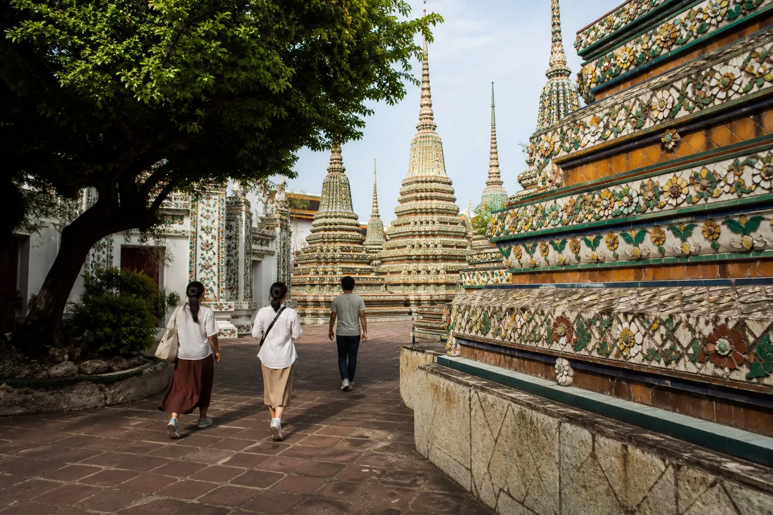 Thai temple architecture and a visitor walking through the grounds