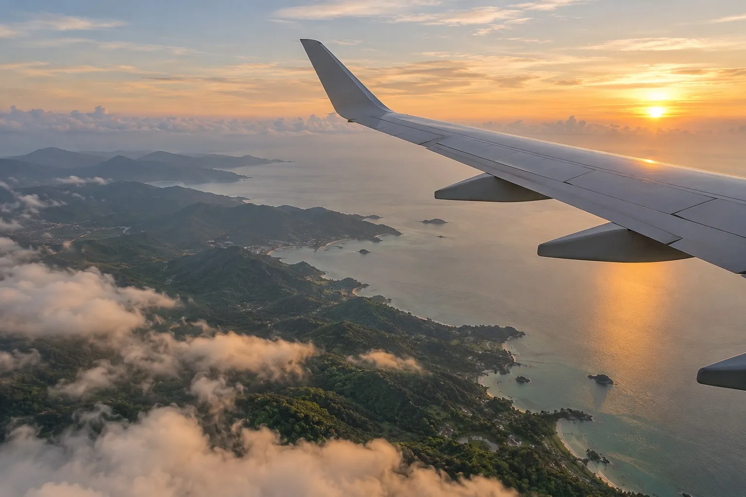 View over an aircraft wing at sunrise above the green Thai coastline